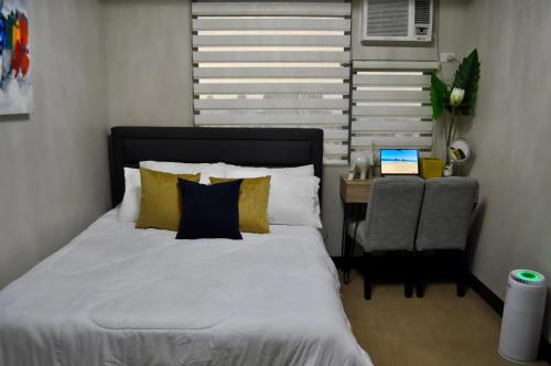 a bedroom with a bed and a chair and a window at Casa De Camelina in Manila