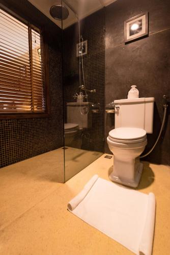 a bathroom with a toilet and a glass shower at La Siesta Hoi An Resort & Spa in Hoi An