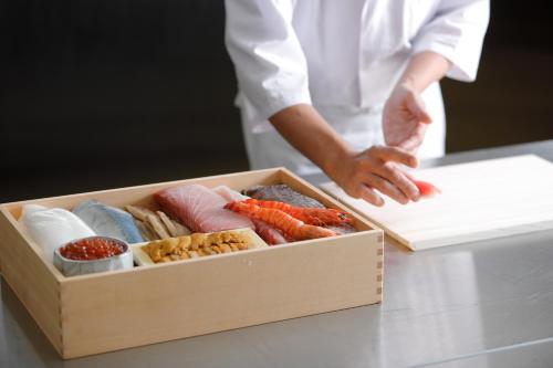 a chef standing next to a box of sushi at The Westin Miyako Kyoto in Kyoto