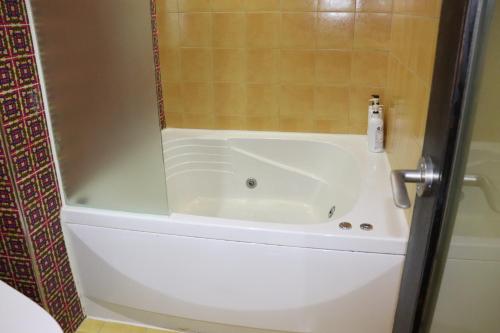 a bath tub in a bathroom with a shower at Hotel Marigold in Incheon