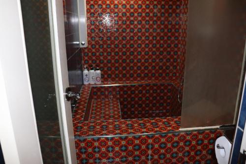 a bathroom with a shower with a red wall at Hotel Marigold in Incheon