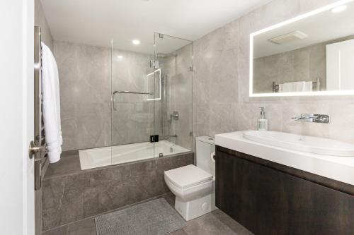 a bathroom with a sink and a toilet and a tub at Amazing Location - 2BDRM/2BATH - right on Robson in Vancouver