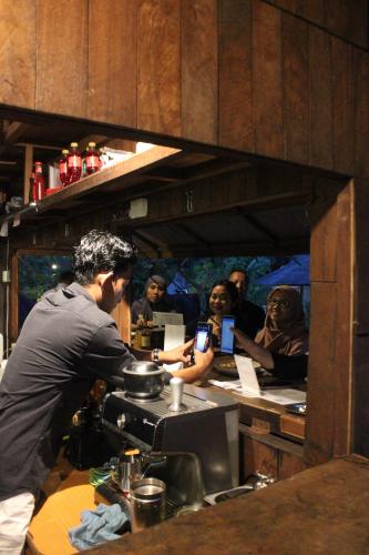a man standing in a kitchen with a group of people at Natuna Dive Resort in Ranai