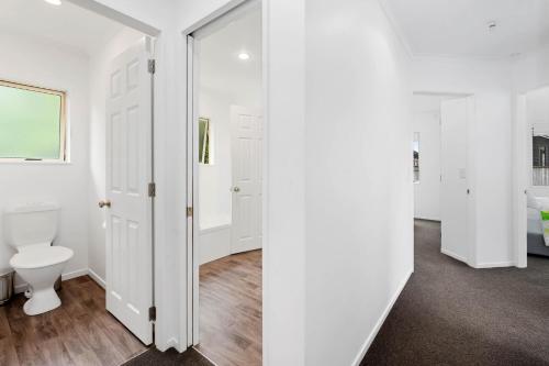 a white bathroom with a toilet and a window at Lakeside Haven - Taupo Holiday Home in Taupo