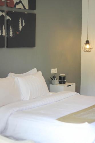 a bedroom with a white bed and a lamp at Natuna Dive Resort in Ranai