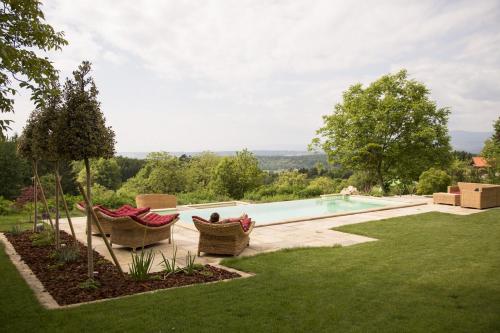 a backyard with a swimming pool and two chairs at Landvilla Pia in Attendorf
