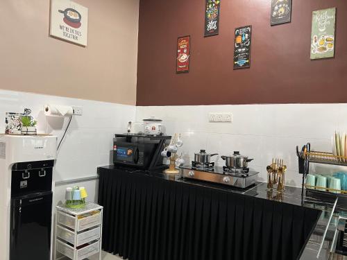 a kitchen with a counter with a stove and a microwave at Kayangan Homestay Kuantan MUSL!M Only in Kuantan