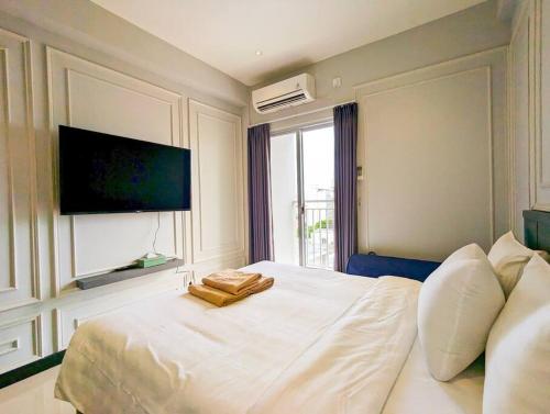 een slaapkamer met een wit bed en een flatscreen-tv bij Lovina 8-25 @Citra Plaza Nagoya in Nagoya