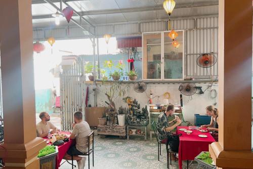 um grupo de pessoas sentadas em mesas em um restaurante em Cat Ba Mystery Homestay em Ilha de Cát Bà