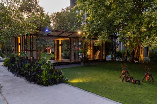 a house with a lot of plants in the yard at Proud Phuket, Naiyang Beach in Nai Yang Beach