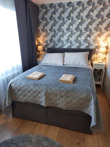 a bedroom with a bed with two towels on it at Centrum Bridge Apartment in Pärnu