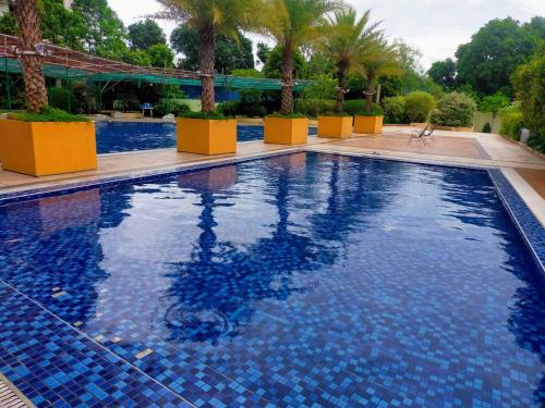 ein Pool mit blauen Fliesen in einem Resort in der Unterkunft Your Desire Staycation in Manila