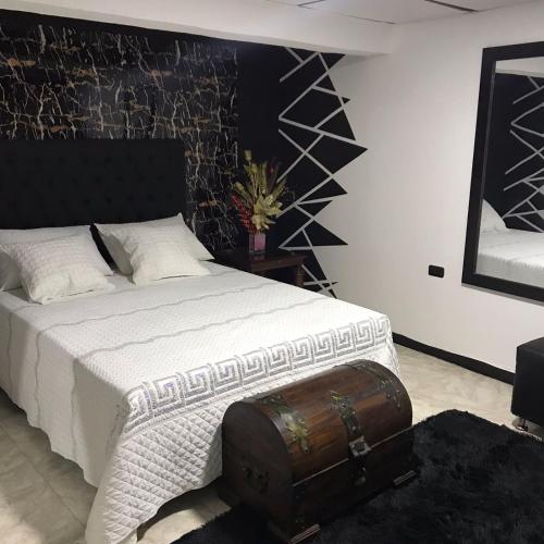 a bedroom with a bed with a suitcase on the floor at la muñeca apartamento in Pereira