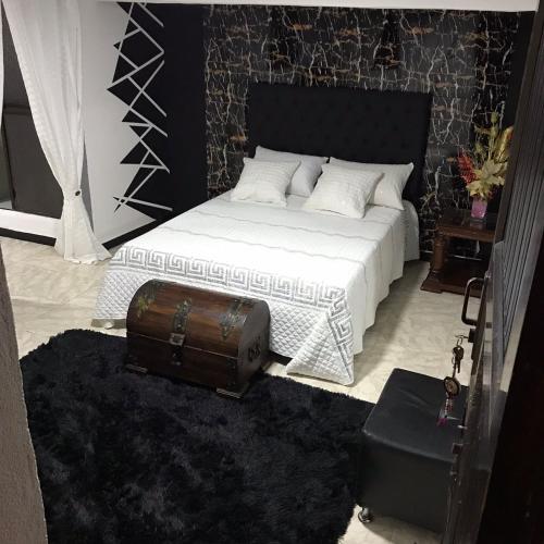 sypialnia z łóżkiem z walizką na podłodze w obiekcie la muñeca apartamento w mieście Pereira