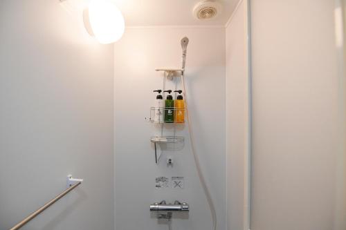 Baño con estante con botellas en la pared en Hotel Tokyo Hub, en Tokio
