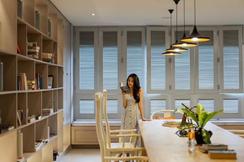 a woman standing at a table in a room at Proud Phuket, Naiyang Beach in Nai Yang Beach
