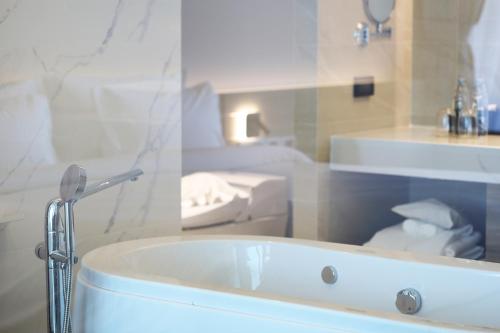 a bathroom with a tub and a toilet and a sink at The Signature Hotel Airport in Hat Yai