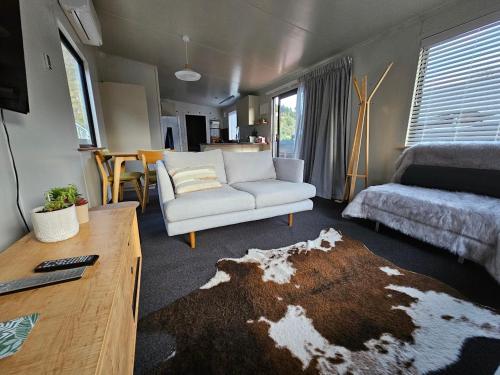 ein Wohnzimmer mit einem Sofa und einem Bett in der Unterkunft Roxburgh Central in Roxburgh