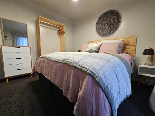 1 dormitorio con cama, tocador y espejo en Roxburgh Central en Roxburgh