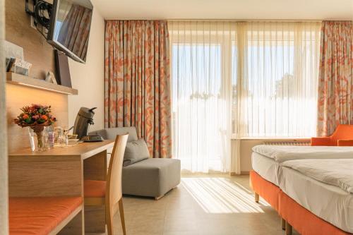 um quarto de hotel com uma cama e uma secretária e um quarto em Hotel Bergschlößchen em Simmern