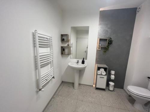 Baño blanco con lavabo y aseo en Hope, en Cluj-Napoca