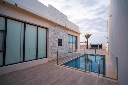 a house with a swimming pool and a patio at REMAL INN in Bidiyah