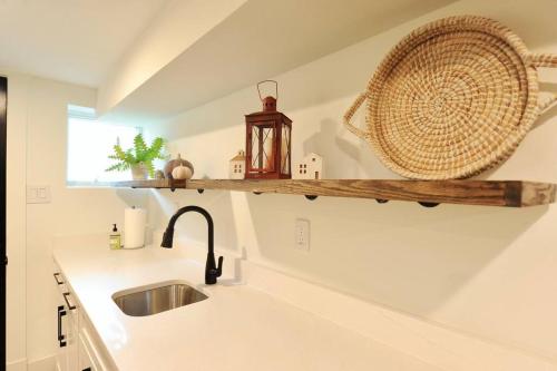 cocina con fregadero y estante en la pared en Cherry Blossom Townhouse, Easy DC Access en Washington