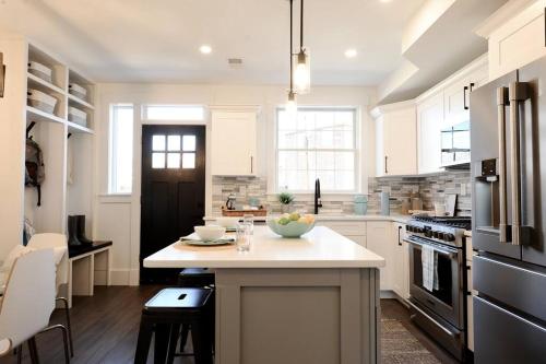 a kitchen with a island with a bowl of fruit on it at Cherry Blossom Townhouse, Easy DC Access in Washington, D.C.