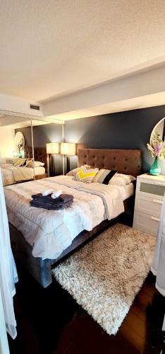 a bedroom with a large bed with a wooden headboard at Lakefront living Downtown Toronto - Free Parking, Gym, Indoor Pool in Toronto