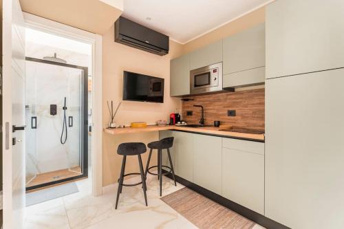 a kitchen with white cabinets and two stools at Civico 2Cento - Vatican Suite in Rome