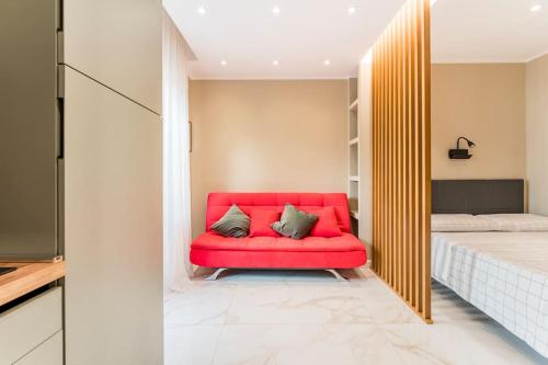 a red couch in a room with a bed at Civico 2Cento - Vatican Suite in Rome