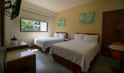 Habitación de hotel con 2 camas y ventana en Olmeca Plaza Urban Express en Villahermosa