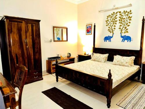 a bedroom with a large bed and a wooden cabinet at *Serene* A Luxurious Stay in Jodhpur