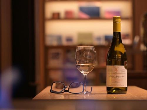 a bottle of wine and a pair of glasses on a table at Chalet Shiga in Yamanouchi