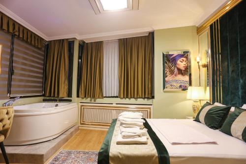 een slaapkamer met een bad en een bed met handdoeken bij WHITEMOON HOTEL SUİTES in Istanbul