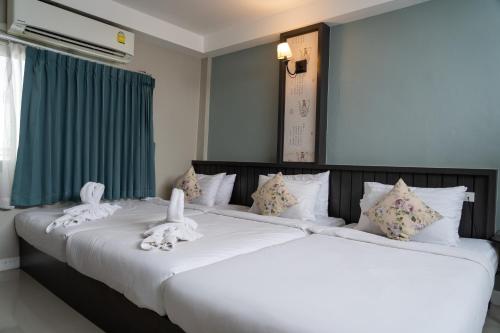 dwa łóżka z białymi pluszakami na górze w obiekcie We World Boutique Haatyai w mieście Hat Yai