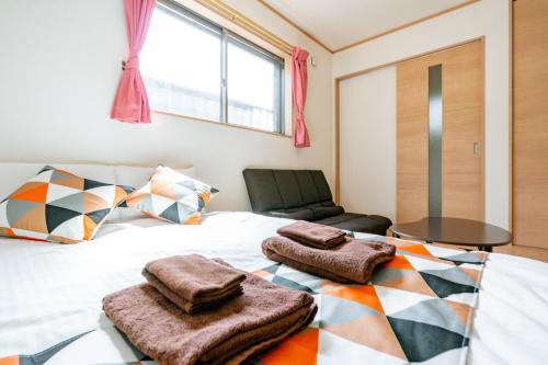 a bedroom with a bed with towels on it at Ferio101 in Tokyo