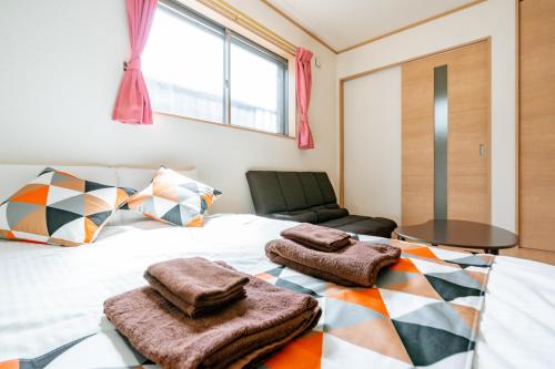 a bedroom with a bed with towels on it at Ferio in Tokyo