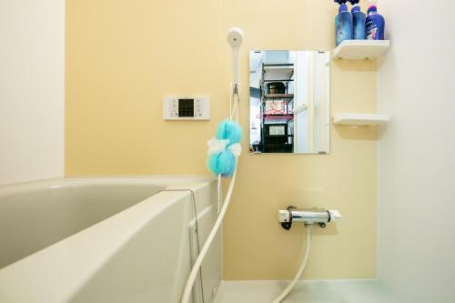 a bathroom with a white bath tub with a blue at Ferio in Tokyo