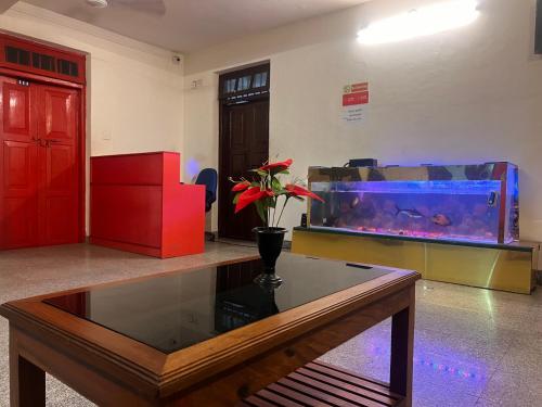 a living room with a fish tank and a table at Hotel Sunday - Townhouse Club Airport Trivandrum in Trivandrum