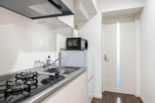 a kitchen with a sink and a stove at GRANDE Morisita in Tokyo