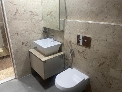 a bathroom with a white toilet and a sink at LCH Fitness in Indore