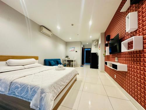 Teddy Apartment at Sky Center Luxury في مدينة هوشي منه: غرفة نوم بسرير وجدار من الطوب