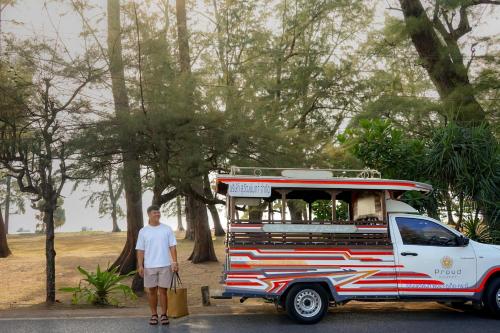 a man is standing next to a food truck at Proud Phuket, Naiyang Beach in Nai Yang Beach