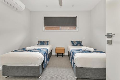 a room with three beds and a window at Comfort Suites Clubarham Golf Resort in Barham