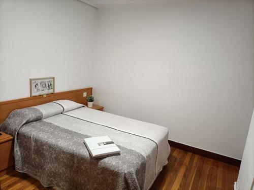 a bedroom with a bed with a book on it at Apartamento familiar gran Bilbao in Basauri