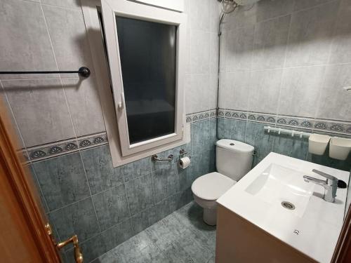a bathroom with a toilet and a sink and a mirror at Apartamento familiar gran Bilbao in Basauri