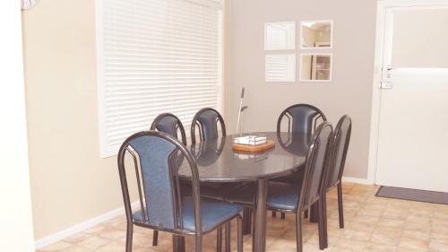 a dining room with a black table and chairs at Pet Friendly Cockatoo Corner in Armidale