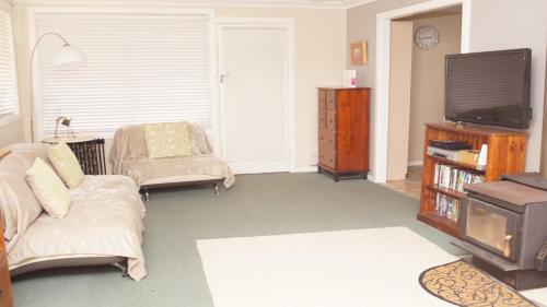 a living room with a couch and a tv at Pet Friendly Cockatoo Corner in Armidale