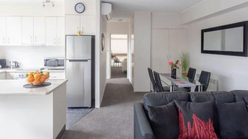 a kitchen and a living room with a refrigerator at central park boutique apartment in Armidale